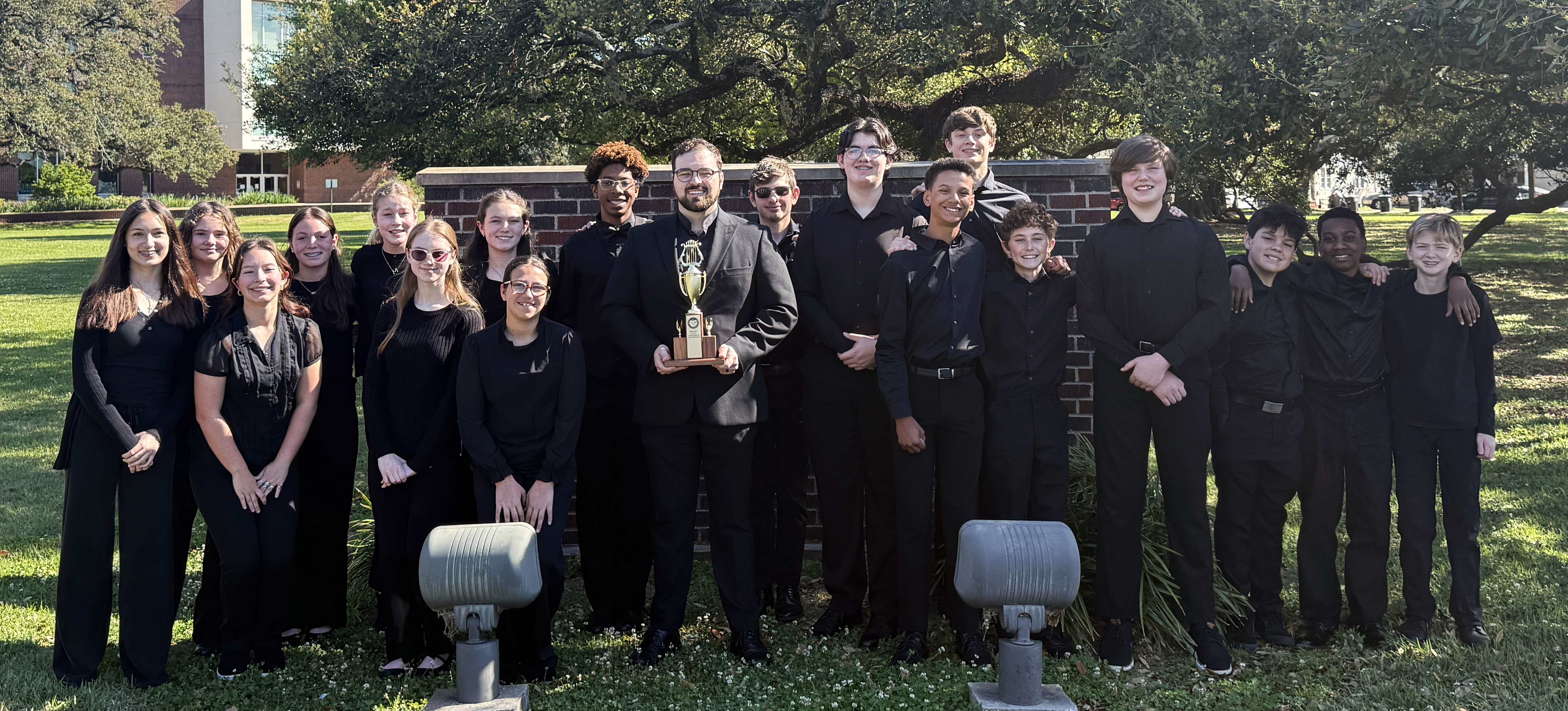 Orchestra Students posing with their new trophy